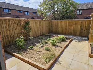 a garden in front of a wooden fence at Prenton House, 3BR Close to Liverpool in Birkenhead