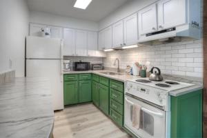 eine Küche mit grünen Schränken und einem weißen Kühlschrank in der Unterkunft Studio Purgatory Townhome 111 in Durango Mountain Resort