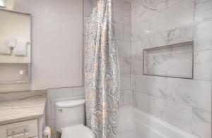 ein Bad mit einem Duschvorhang und einem WC in der Unterkunft Studio Purgatory Townhome 111 in Durango Mountain Resort + 28 Fotos