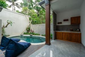 een zwembad in de achtertuin met een hot tub en een keuken bij De Rekun Ubud in Ubud