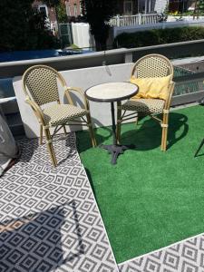 twee stoelen en een tafel op een patio met gras bij NY3182-9 Private Office w Double SofaBed Keypad in Unionport
