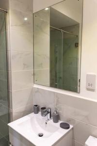 ein weißes Badezimmer mit einem Waschbecken und einem Spiegel in der Unterkunft Paradise 1 bedroom Apartment @Embassy Gardens in Cantonments