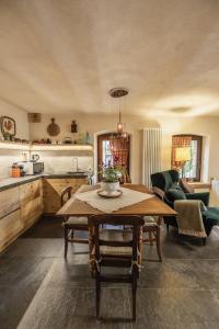 ein Wohnzimmer mit einem Tisch und einer Küche in der Unterkunft La Casa del cuore in Fenis