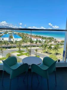 uma mesa e cadeiras num quarto com vista para o oceano em Seaview Cam Ranh Beach Resort Nha Trang Near The Airport Best Location em Cam Ranh