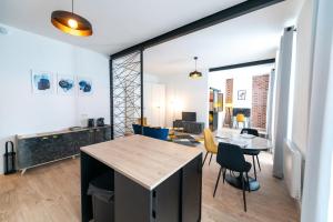 une cuisine et un salon avec une table et des chaises dans l'établissement KASA ARTY - Tout équipé - Agréable et confortable, à Saint-Étienne 29 autres photos