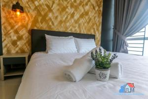 Desaru Luxury Homestay - near WaterPark, RAPID, Beach في دِسارو: سرير عليه بطانية بيضاء وزرع