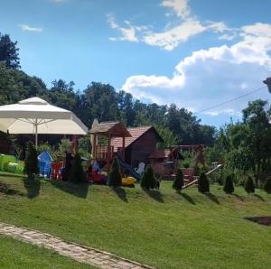 a yard with a playground and an umbrella at Palanačka Avlija 3 in Ripanj