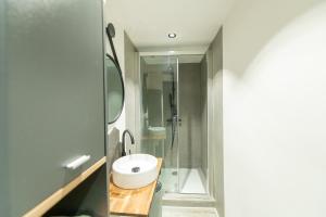 y baño con lavabo y ducha. en KASA ARTY - Tout équipé - Agréable et confortable en Saint-Étienne