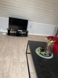 sala de estar con mesa y TV en MyCondo no - Øvre Langgate 24 7 - gratis parkering, en Tønsberg