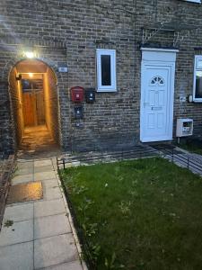 Forest HillにあるGrangemill Garden Annexの白い扉と庭のあるレンガ造りの建物