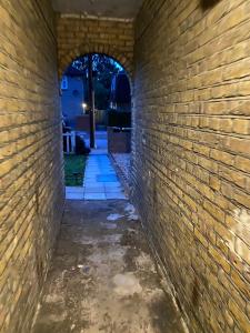 un callejón en una pared de ladrillo con un arco en Grangemill Garden Annex, en Forest Hill