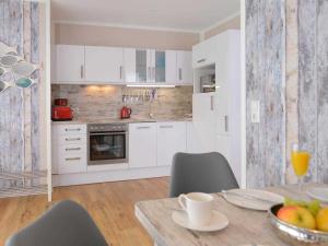 a kitchen with a table with a bowl of fruit on it at Florida Haus am Strand in Boltenhagen