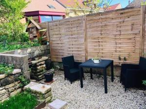 un patio con tavolo e sedie di fronte a una recinzione di RÊVE POUR DEUX a Sampans