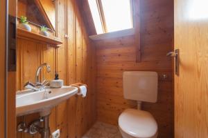 ein Bad mit einem WC, einem Waschbecken und einem Fenster in der Unterkunft VS 7 - Strandvogt Standard in Dorum Neufeld