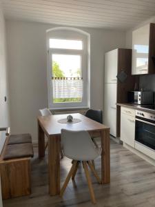 a kitchen with a wooden table with a chair and a table at Ferienwohnung Zeitz Appartment Zeitzer Dom in Zeitz