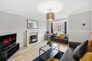 a living room with a couch and a fireplace at Stunning Detached 3 Bed House - Parking & Garden in Bedford