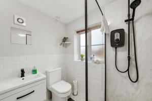 a bathroom with a shower with a toilet and a sink at Stunning Detached 3 Bed House - Parking & Garden in Bedford