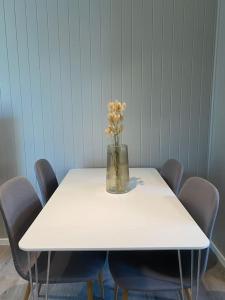 une table blanche avec un vase de fleurs sur elle dans l'établissement Mycondo no - Snorres gt 4b apt 1 - Gratis parkering, à Tønsberg
