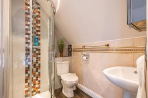 a bathroom with a toilet and a sink and a shower at Loughton House - Central Location - Free Parking, Private Garden, Super-Fast Wifi and Smart TVs by Yoko Property in Milton Keynes