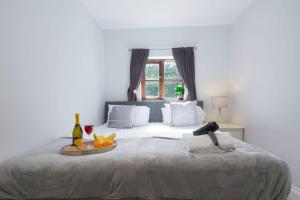 a bedroom with a bed with a tray of fruit on it at Loughton House - Central Location - Free Parking, Private Garden, Super-Fast Wifi and Smart TVs by Yoko Property in Milton Keynes