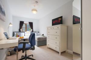 a bedroom with a desk and a bedroom with a bed at Loughton House - Central Location - Free Parking, Private Garden, Super-Fast Wifi and Smart TVs by Yoko Property in Milton Keynes