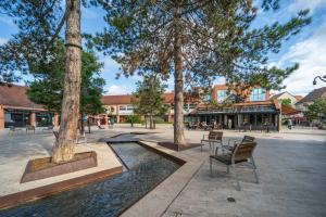 un parc avec des arbres, des chaises et une fontaine dans l'établissement Les Volets Bleus, à Rungis