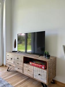 TV en un centro de entretenimiento de madera en una sala de estar en Graz Getaway, en Graz
