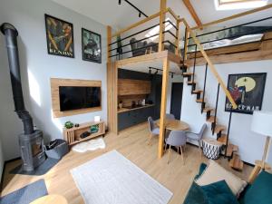 a living room with a loft bed and a spiral staircase at Sub Silva in Bałtów