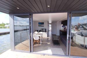 a house on the water with a large deck at Hausboot Fjord Nordstern mit Dachterrasse in Schleswig in Schleswig