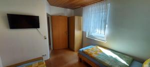a living room with a couch and a tv on the wall at Apartment Popp Langen in Langen