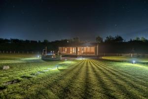 a building in a field at night with lights at porichka in Korostov