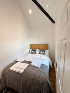 a bedroom with a large bed with white walls at 75 Weavers Townhouse in Norwich