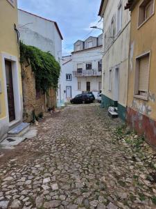 an alley with buildings and a car parked on the street at Zenhouse in São Martinho do Porto