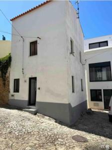 a white building with a door on the side of it at Zenhouse in São Martinho do Porto