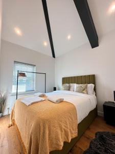 a bedroom with a large bed with a blanket on it at 75 Weavers Townhouse in Norwich