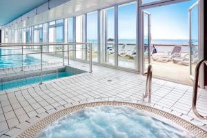 - une baignoire au milieu d'une chambre avec piscine dans l'établissement Hôtel Valdys Thalasso & Spa - l'Escale marine, à Douarnenez