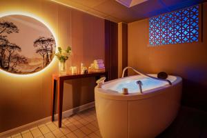 Hôtel Valdys Thalasso & Spa - l'Escale marine في دوارنونيه: حمام مع حوض استحمام و نافذة كبيرة