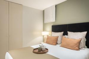 une chambre avec un grand lit blanc avec des oreillers dans l'établissement Carretas Apartments, à Madrid