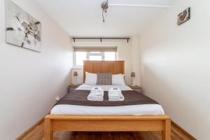 a bedroom with a bed with two white shoes on it at Quiet & Spacious 2BR Flat wGarden near Edmonton in Edmonton