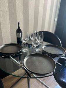 una mesa de cristal con dos platos vacíos y copas de vino en L’authentique, en Nimes
