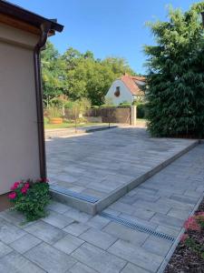 a stone patio with a building and a driveway at Apartmán Květinová zahrada in Prague