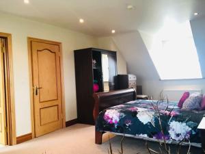 1 Schlafzimmer mit einem Bett mit Blumenbettdecke in der Unterkunft Connemara. 3 Bedroom, 8 bed, Holiday home in Galway