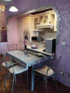 cocina con mesa, sillas y paredes púrpuras en Appartamento Luxury vista mare per 6 persone a Marina Julia, en Marina Julia