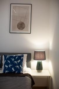 sypialnia z łóżkiem i stołem z lampką w obiekcie B&M - By The Sea Apartments Batorego 7 w mieście Gdynia