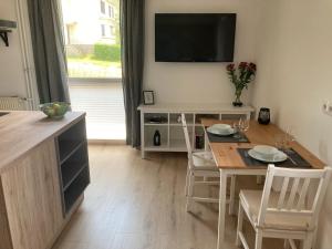 a dining room with a table and a television on a wall at 2 P. Appartement am Kurpark in Bad Driburg