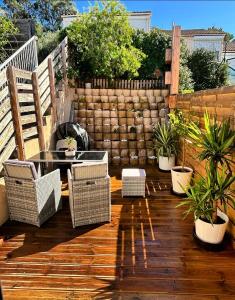 un patio con sillas, una mesa y algunas plantas en Modern apartment , Golfe de Saint Tropez, en Cogolin