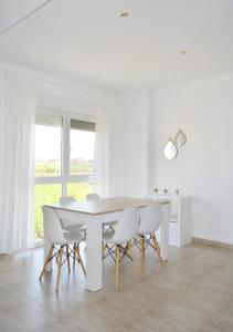 un comedor blanco con una mesa y sillas blancas en Duplex con gran terraza en Càlig, en Cálig