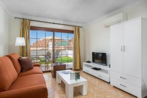 a living room with a couch and a tv at Sunset View Club in San Miguel de Abona