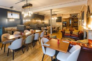 a restaurant with tables and chairs and a couch at Traquair Arms Hotel in Innerleithen
