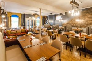 a restaurant with tables and chairs and a brick wall at Traquair Arms Hotel in Innerleithen